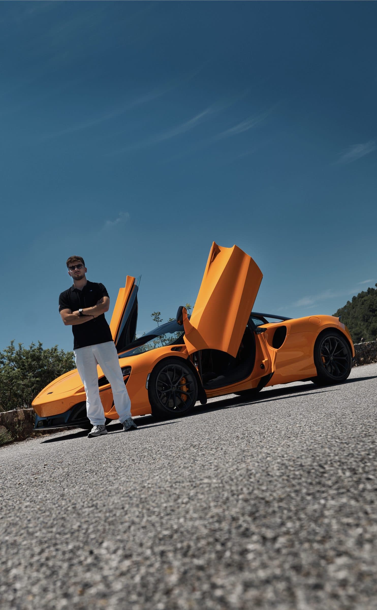 Lucas Valkre debout devant la McLaren, portes ouvertes